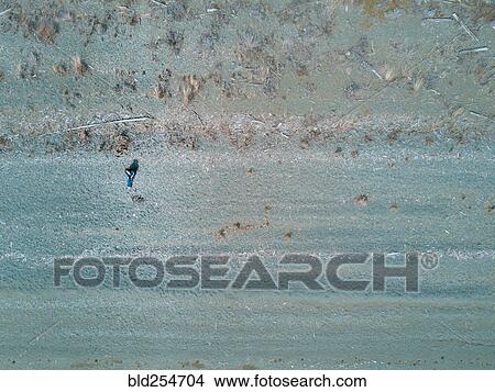 Aerial view of Caucasian woman sitting on beach View Large Photo Image Picture - Aerial view of Caucasian woman sitting on beach. Fotosearch