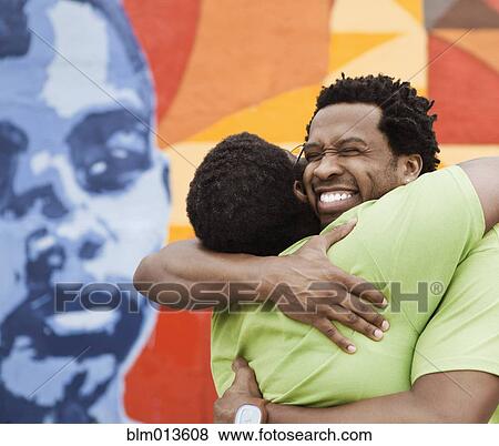Stock Photo - African American friends hugging. Fotosearch