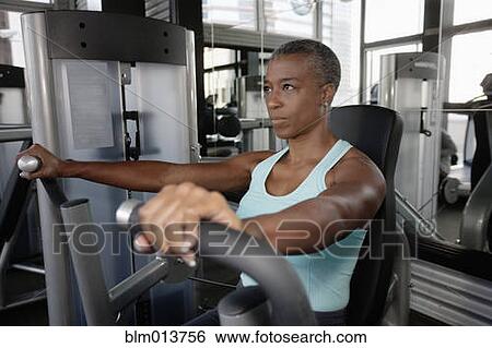 Stock Photograph - African American woman exercising in health club. Fotosearch