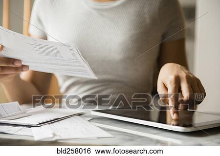 African American woman paying bills with digital tablet View Large Photo Image Stock Photograph - African American woman paying bills with digital tablet. Fotosearch
