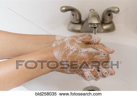 Stock Photography - African American woman washing hands with soap. Fotosearch
