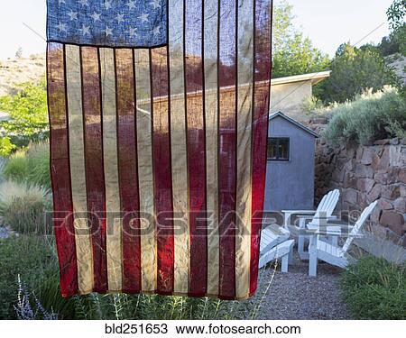 Stock Image - American flag hanging near house. Fotosearch
