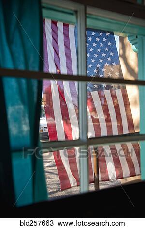 Stock Image - American flag hanging outside window. Fotosearch