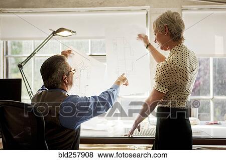 Stock Photo - Architects examining blue1int in office. Fotosearch