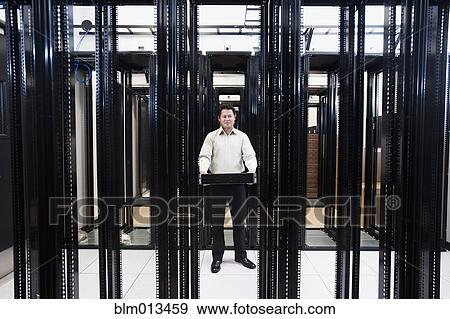 Stock Photo - Asian businessman standing in empty server room. Fotosearch