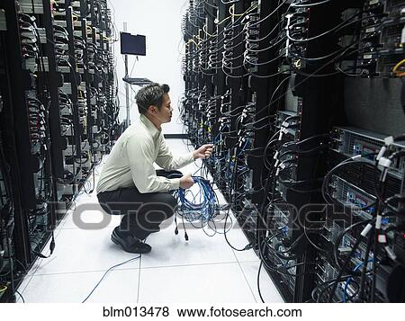 Asian businessman working in server room View Large Photo Image Stock Photo - Asian businessman working in server room. Fotosearch
