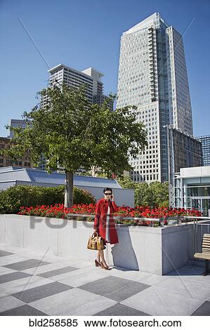 Stock Photography - Asian businesswoman talking on cell phone outdoors. Fotosearch