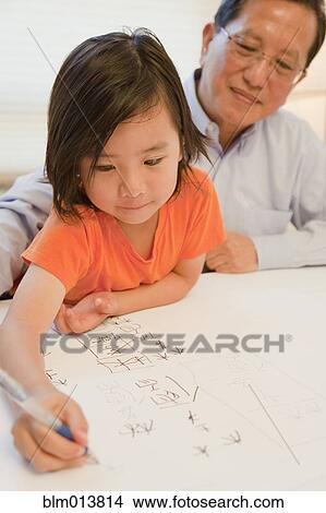 Asian grandfather watching grandson writing View Large Photo Image Picture - Asian grandfather watching grandson writing. Fotosearch