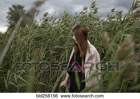 Asian woman standing in field of tall grass View Large Photo Image Stock Photograph - Asian woman standing in field of tall grass. Fotosearch