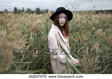 Stock Photo - Asian woman standing in field. Fotosearch