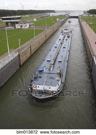 Barge traveling through canal View Large Photo Image Stock Image - Barge traveling through canal. Fotosearch