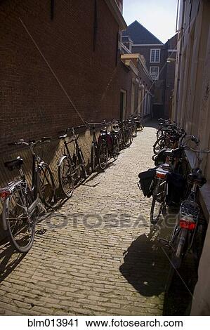 Bicycles parked in Dutch alley View Large Photo Image Stock Image - Bicycles parked in Dutch alley. Fotosearch