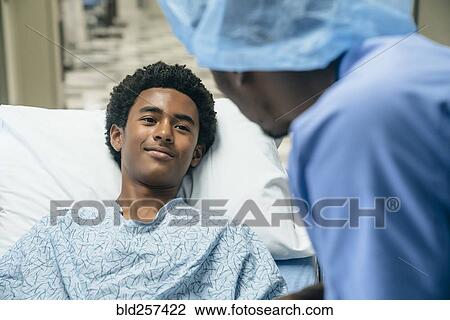 Black doctor talking to boy in hospital bed View Large Photo Image Stock Image - Black doctor talking to boy in hospital bed. Fotosearch