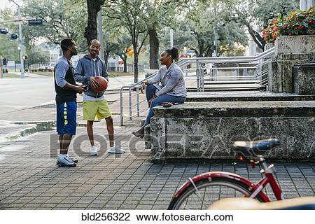 Stock Image - Black friends with basketball hanging out. Fotosearch