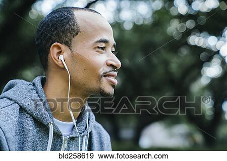 Stock Photo - Black man listening to earbuds. Fotosearch