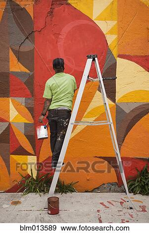 Stock Photo - Black man painting wall. Fotosearch