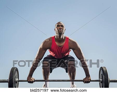 Stock Photo - Black man preparing for lifting barbell. Fotosearch