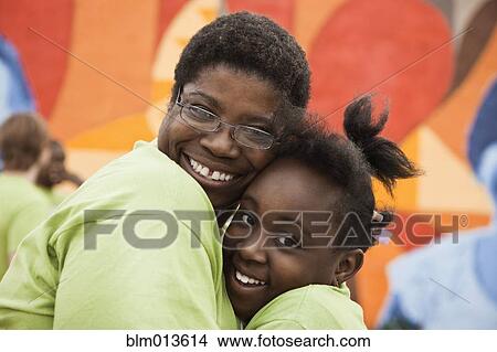 Picture - Black mother and daughter hugging. Fotosearch