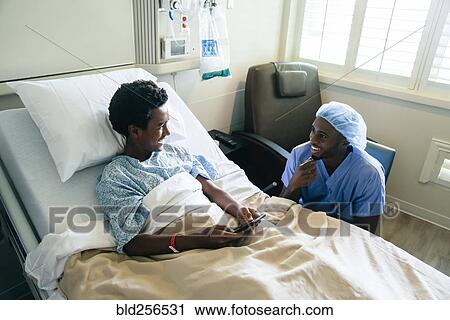 Black nurse talking to boy in hospital bed View Large Photo Image Stock Image - Black nurse talking to boy in hospital bed. Fotosearch