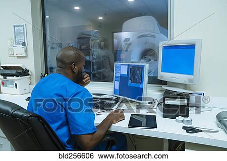 Black nurse using computer near scanner View Large Photo Image Stock Photograph - Black nurse using computer near scanner. Fotosearch