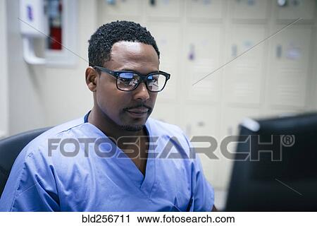 Stock Image - Black nurse using computer. Fotosearch