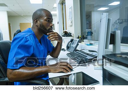 Stock Photo - Black nurse using computer. Fotosearch