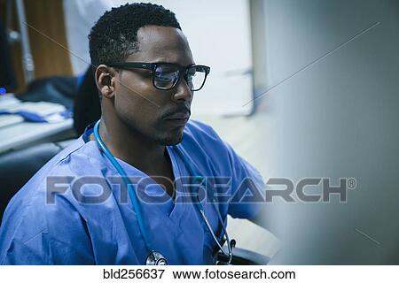 Stock Photo - Black nurse using computer. Fotosearch