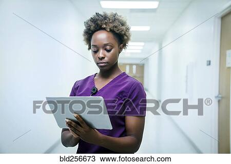Black nurse using digital tablet in hospital View Large Photo Image Stock Image - Black nurse using digital tablet in hospital. Fotosearch