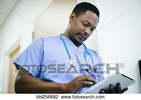 Black nurse using digital tablet in hospital View Large Photo Image Stock Image - Black nurse using digital tablet in hospital. Fotosearch