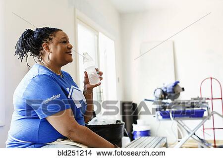 Black volunteer woman drinking water View Large Photo Image Picture - Black volunteer woman drinking water. Fotosearch