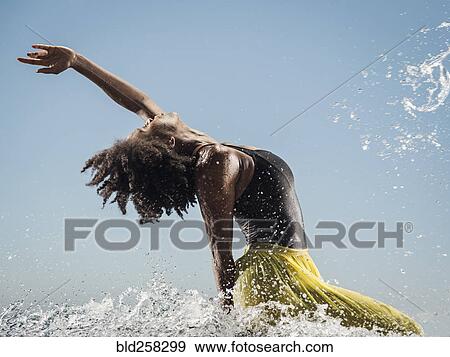 Stock Photo - Black woman dancing in water. Fotosearch
