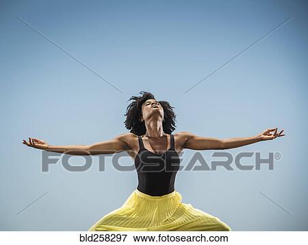 Stock Photo - Black woman dancing with arms outstretched. Fotosearch