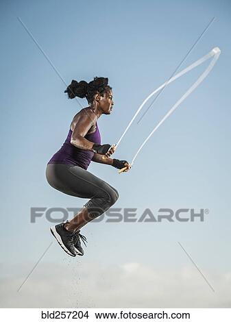 Black woman jumping rope in sky View Large Photo Image Picture - Black woman jumping rope in sky. Fotosearch