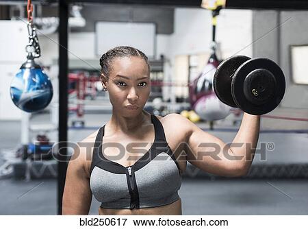 Black woman lifting dumbbell in gymnasium View Large Photo Image Stock Photo - Black woman lifting dumbbell in gymnasium. Fotosearch
