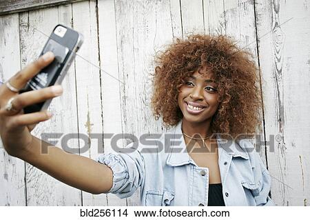 Black woman posing for cell phone selfie View Large Photo Image Picture - Black woman posing for cell phone selfie. Fotosearch