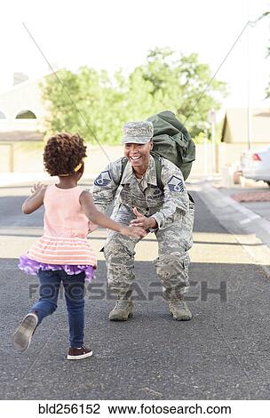 Stock Image - Black woman soldier greeting daughter in street. Fotosearch