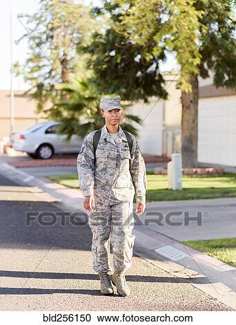 Stock Image - Black woman soldier walking in street. Fotosearch