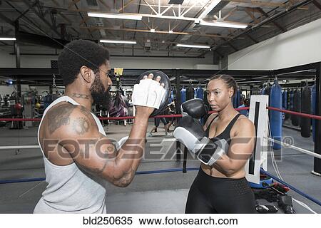 Black woman sparring with trainer in boxing ring View Large Photo Image Stock Photography - Black woman sparring with trainer in boxing ring. Fotosearch