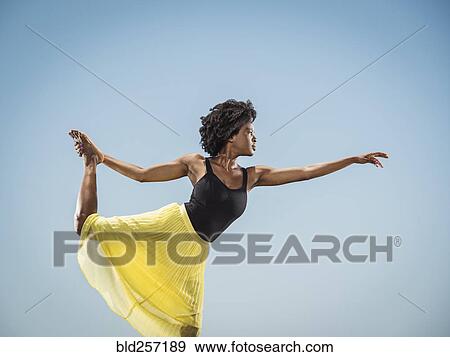 Black woman standing on one leg holding foot View Large Photo Image Stock Photo - Black woman standing on one leg holding foot. Fotosearch