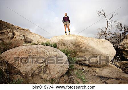 Black woman standing on top of rock View Large Photo Image Picture - Black woman standing on top of rock. Fotosearch