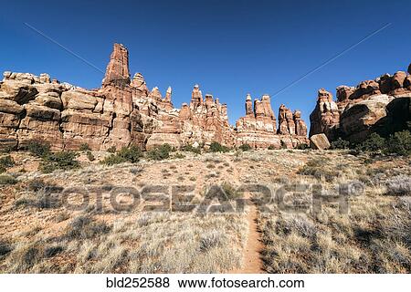 Stock Photo - "Blue sky over desert path, Moab, Utah, United States". Fotosearch