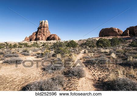 Stock Photograph - "Blue sky over desert path, Moab, Utah, United States". Fotosearch
