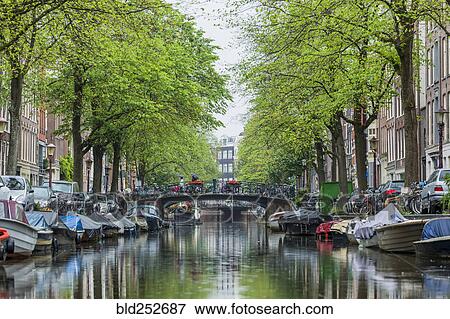 Stock Photo - Boats near bridge over urban canal. Fotosearch