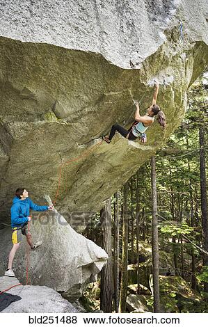 Stock Photo - Boy watching girl rock climbing. Fotosearch