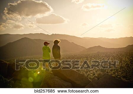 Boys standing on rock admiring desert landscape View Large Photo Image Stock Photography - Boys standing on rock admiring desert landscape. Fotosearch