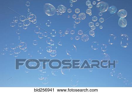 Stock Image - Bubbles floating in blue sky. Fotosearch