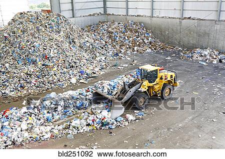 Stock Image - Bulldozer pushing trash. Fotosearch