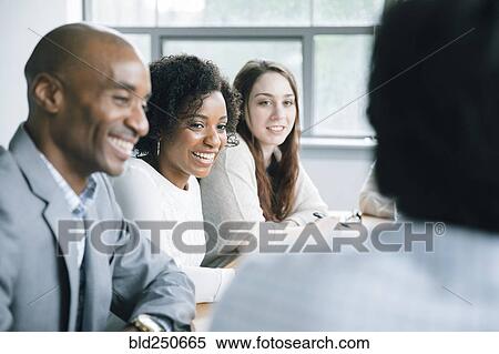 Stock Photography - Business people laughing in meeting. Fotosearch