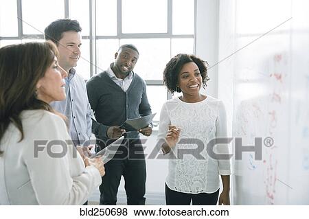 Business people reading whiteboard in meeting View Large Photo Image Stock Photo - Business people reading whiteboard in meeting. Fotosearch