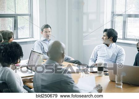 Stock Photo - Business people talking behind window in meeting. Fotosearch